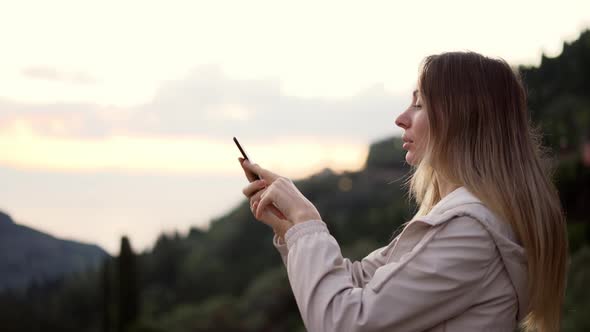 Long Haired Woman Takes a Photo with a Smartphone in Her Hands