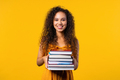 Happy student woman with stack of books from library on yellow background - PhotoDune Item for Sale