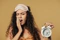 Sleepy woman yawns with alarm clock. Faded yellow background. Early 6 o'clock - PhotoDune Item for Sale