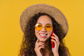 Attractive woman talking by phone, smiling. Young lady on yellow background. - PhotoDune Item for Sale