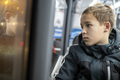 Teenage boy in jacket traveling by bus in evening city - PhotoDune Item for Sale