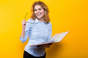 shirt and glasses isolated on orange background checking readings in open big folder with files graduate or course work report presentation concept.