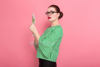  blouse and eyeglasses holding fan of euro bills isolated on pink background with copyspace winning in lottery money withdraw concept.