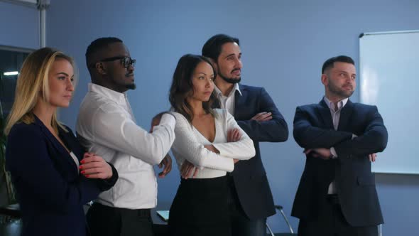 Business Team Standing with Serious Look in Office