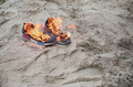 Burning sports sneakers or gym shoes on fire stand on sandy beach coast - PhotoDune Item for Sale