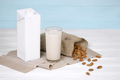 Glass of almond milk with almond nuts on canvas fabric on white wooden table - PhotoDune Item for Sale