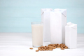 Glass of almond milk with almond nuts on canvas fabric on white wooden table - PhotoDune Item for Sale