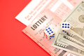 Red lottery ticket with dice and money lies on pink gambling sheets with numbers - PhotoDune Item for Sale