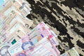 Ukrainian hryvnya bills on fabric with texture of Ukrainian military pixeled camouflage - PhotoDune Item for Sale