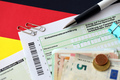 German income tax return form with pen and european euro money bills lies on flag close up - PhotoDune Item for Sale
