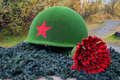 Murmansk, Barents Sea: Soldier monument with helmet and red carnation flower. - PhotoDune Item for Sale