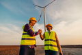 Two engineers standing in field with wind turbines - PhotoDune Item for Sale