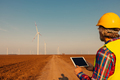 Engineer checking wind turbines at field and using technology - PhotoDune Item for Sale