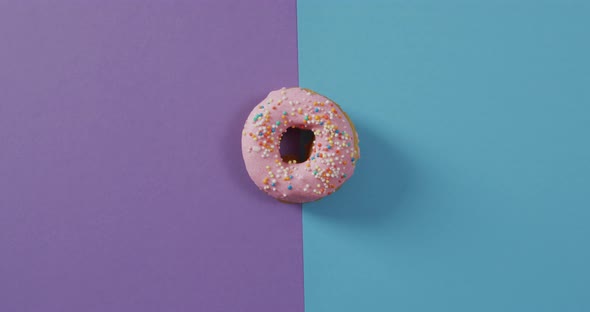 Video of donut with icing on purple and blue background