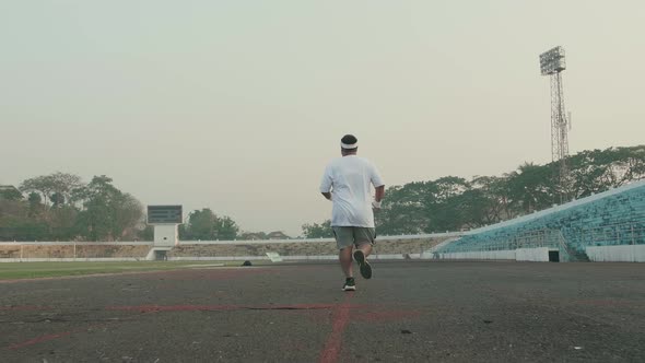 Overweight Man Running At Stadium