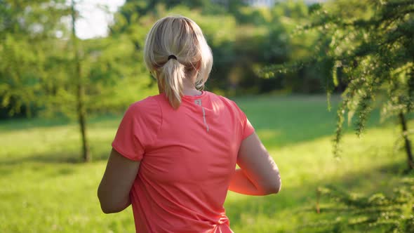 Mature Woman Doing Sports Outdoors on a Sunny Summer Day in Park