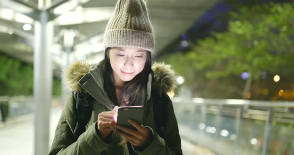 Asian Woman use of mobile phone in city at night