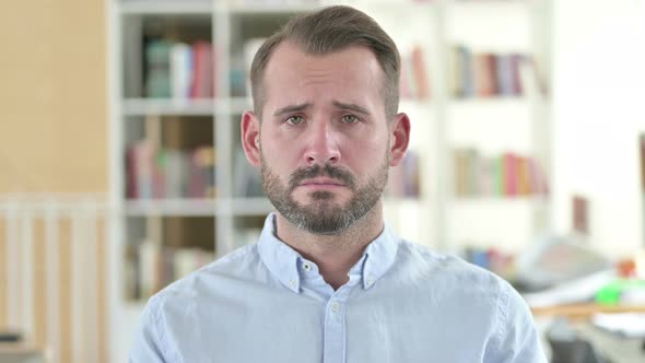 Portrait of Sad Young Man Looking At Camera, Upset 