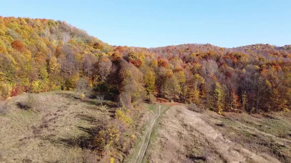 Aerial view of country hills at sunset in autumn season. Beautiful rural scene with dead nature, ear