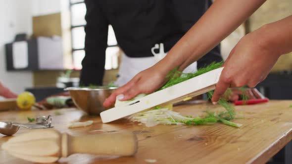 Caucasian female chef teaching diverse group wearing face masks