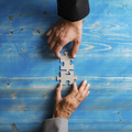 Business partners matching two puzzle pieces in a conceptual image of a merger - PhotoDune Item for Sale