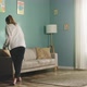 Young Lady in White Sweater Wipes Dust From Furniture - VideoHive Item for Sale