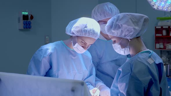 Medical Team Performing Surgical Operation in Bright Modern Operating Room