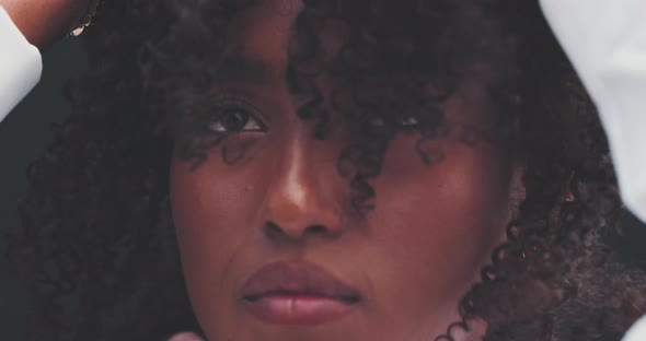 Close up of a black woman raising her hair while a friend fixes her shirt