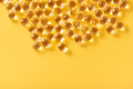 Closeup of oil gel capsules on yellow background. - PhotoDune Item for Sale
