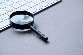 Search engine optimization. Keyboard and magnifying glass.