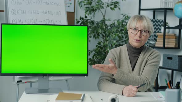 Online Tutor Pointing at Computer with Chroma Key Green Screen Teaching Class During Video Call alt