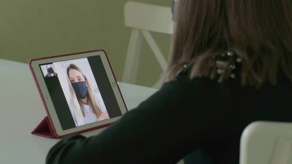 Two Young Women Are Talking Via Video Link in Medical Masks