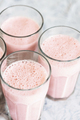 Top view on glasses of strawberry milkshake or smoothie on table. - PhotoDune Item for Sale