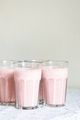 Glasses of strawberry milkshake or smoothie on table. - PhotoDune Item for Sale