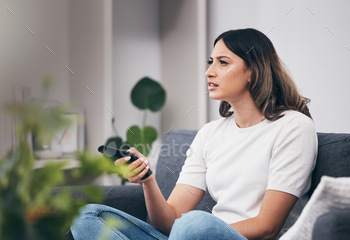 Woman confused watching tv, streaming with remote control and relax at home, thinking or vision pro