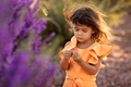 Little toddler girl playing with purple flower, springtime and summer kids portrait - PhotoDune Item for Sale