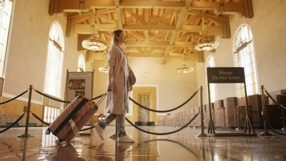 Airport Terminal Beautiful Smiling Woman with Luggage Waling Railroad Station