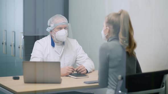 Modern Private Clinic Young Female at a Doctor's Appointment Adult Man Doctor and a Young Woman in