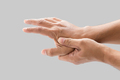 A man grab hand palm because the hand palm was injured. Hand pain. On a gray background. - PhotoDune Item for Sale