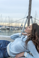 Beautiful woman in casual clothes posing on a sailboat in a city harbor on a cloudy day. - PhotoDune Item for Sale