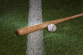 Baseball and bat on grass field with white stripe - PhotoDune Item for Sale