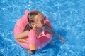 Girl swims in an outdoor pool in fresh air on hot sunny day at hotel on vacation - PhotoDune Item for Sale