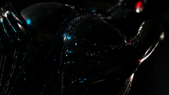 Closeup of a Female Ass in a Black Latex Suit on a Dark Background