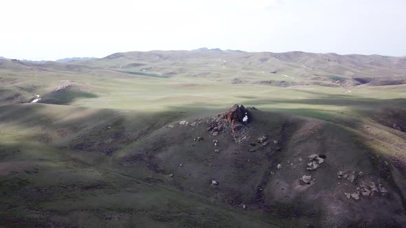 A Huge Rock on the Edge of a Green Hill