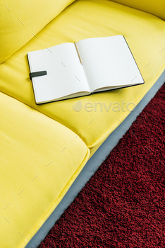 Empty textbook pages with pencil on yellow couch