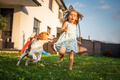 Baby girl running with beagle dog in garden on summer day. Domestic animal with children concept. - PhotoDune Item for Sale