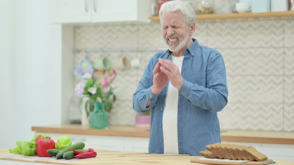 Serious Old Man Crying While Standing in Kitchen