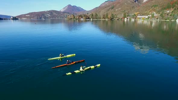 Three kayakers paddle in a scenic mountain lake