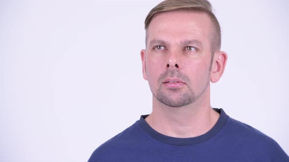 Head Shot of Happy Blonde Man Thinking and Wearing Blue Shirt