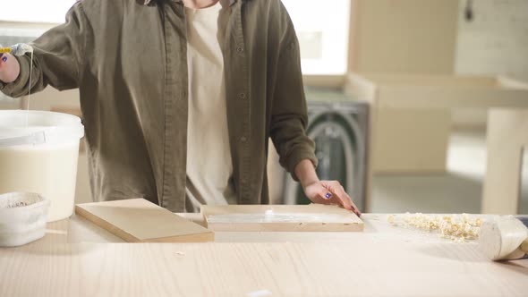 Female Woodworker Treating Wood with Protection Paint and Polishing